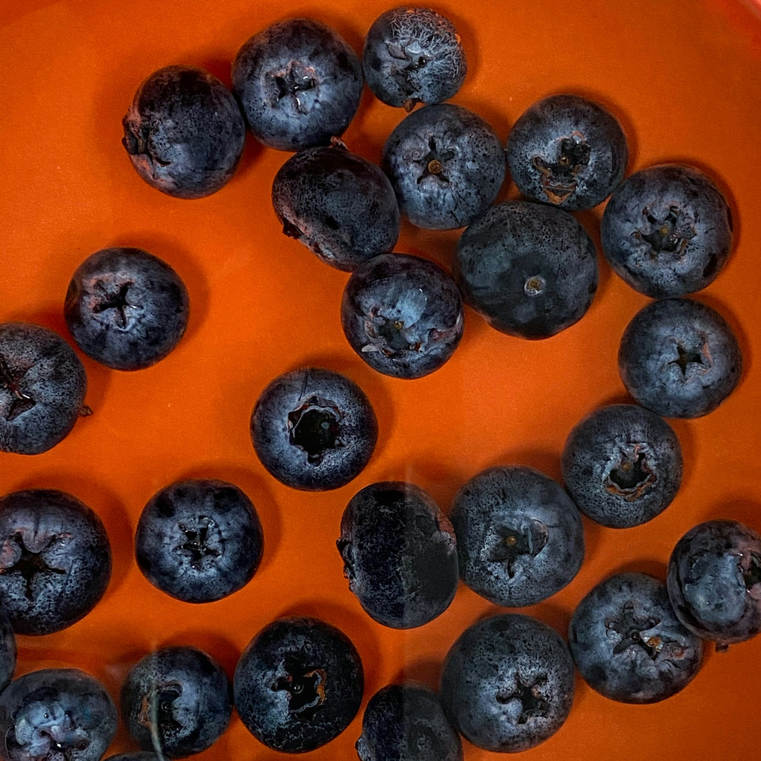 black round fruits on orange container