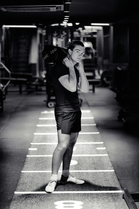 a man standing in a parking garage talking on a cell phone