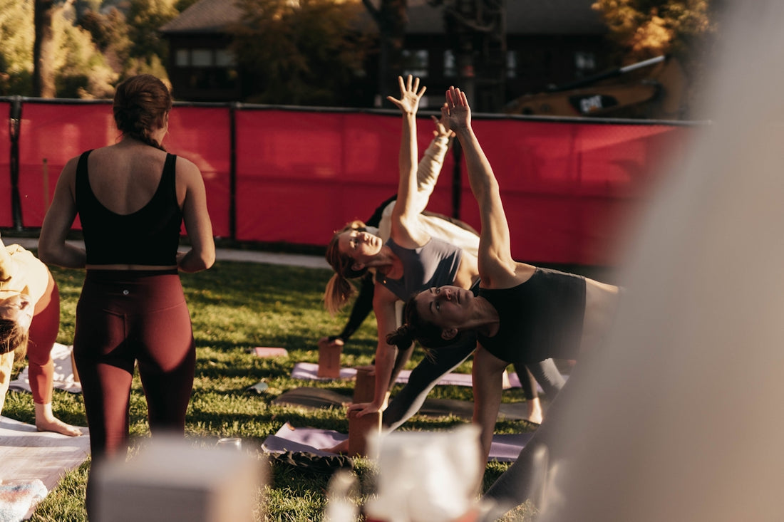 a group of people doing yoga in a park