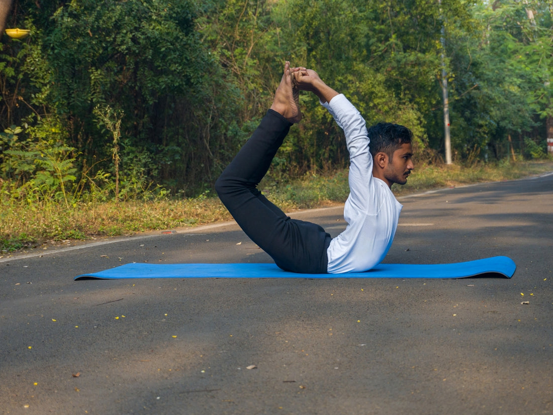 A man doing a yoga pose on a blue mat