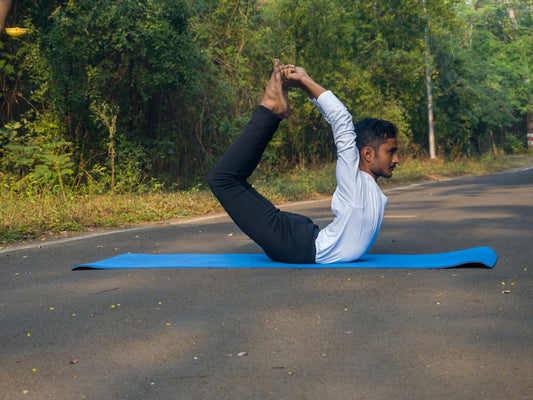 A man doing a yoga pose on a blue mat