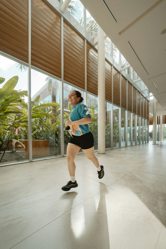 A woman runs down a bright, modern hallway.