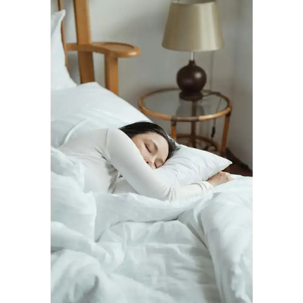 Sleeping woman in white bedding.